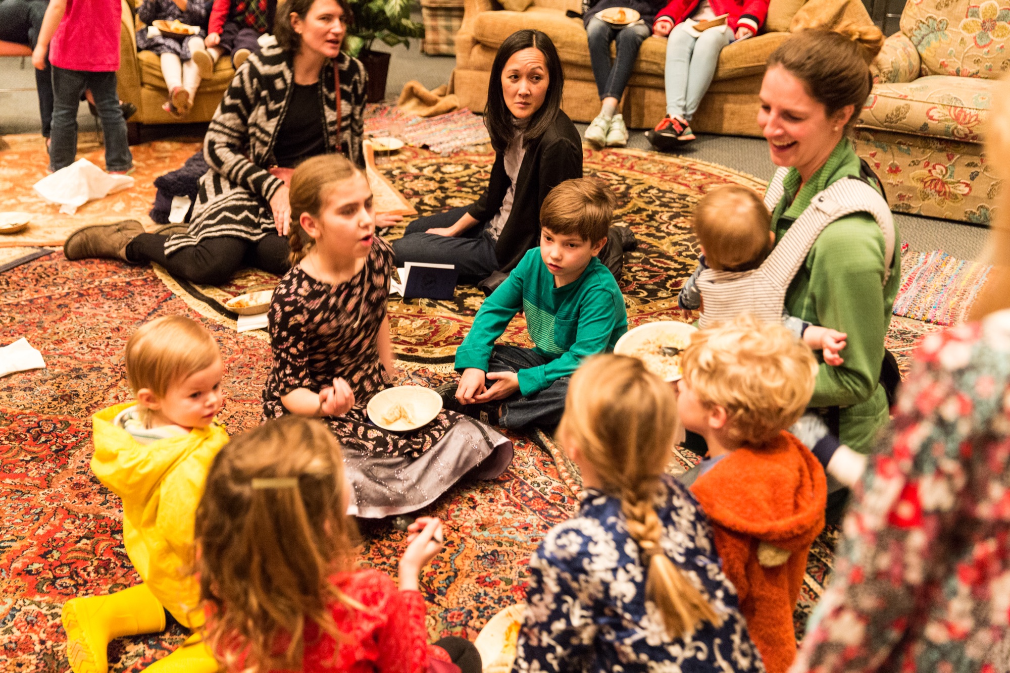 Families gathered on rugs at Taste and See